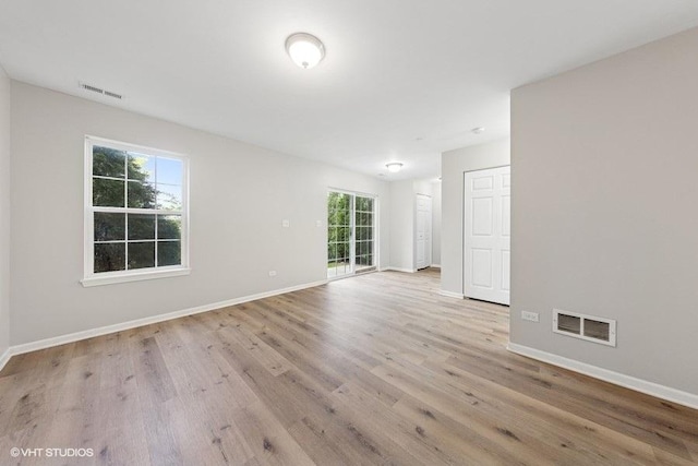 empty room with visible vents, wood finished floors, and baseboards