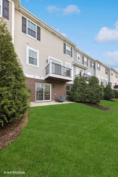 rear view of property with a yard and brick siding
