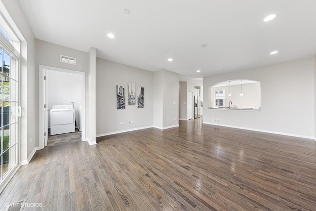 unfurnished living room with visible vents, washer / clothes dryer, wood finished floors, and recessed lighting