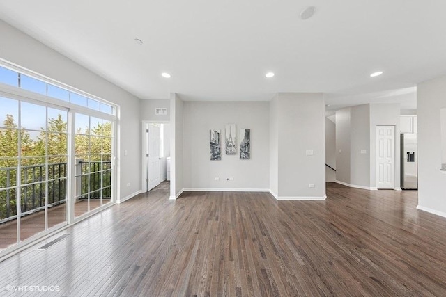 unfurnished living room featuring dark wood-type flooring, recessed lighting, and baseboards