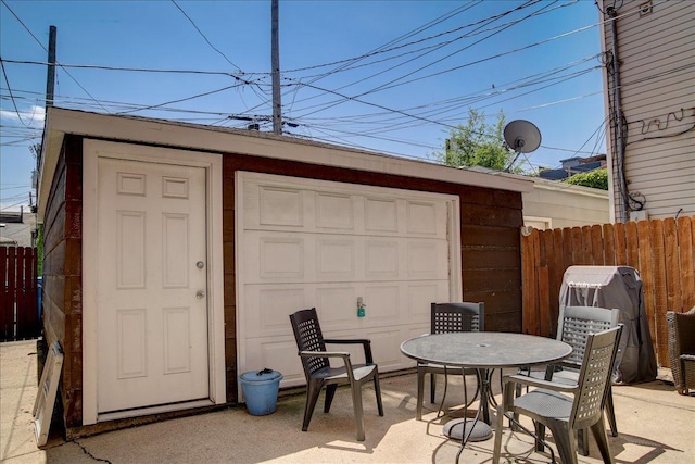 garage with fence and a storage shed