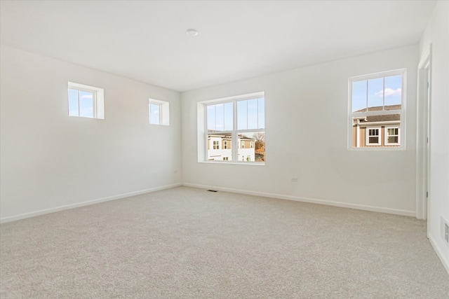 empty room featuring carpet floors and baseboards