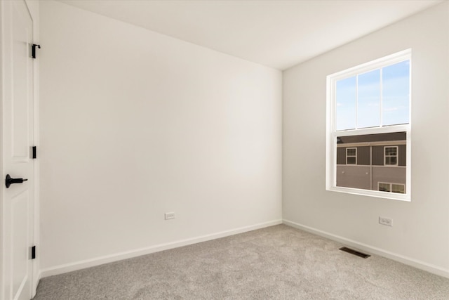 empty room with carpet, baseboards, and visible vents