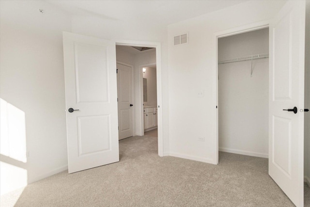 unfurnished bedroom with a closet, baseboards, visible vents, and light carpet