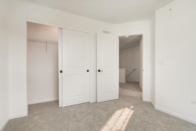 unfurnished bedroom featuring a closet, baseboards, visible vents, and carpet