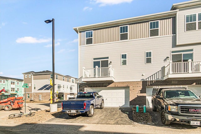 back of property with brick siding, driveway, and an attached garage