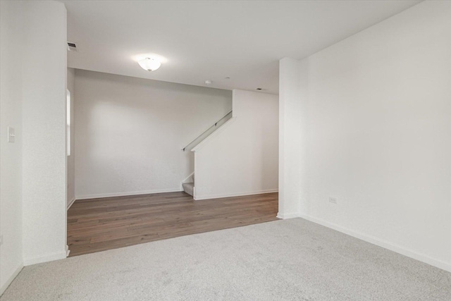 below grade area featuring baseboards, carpet floors, and stairway
