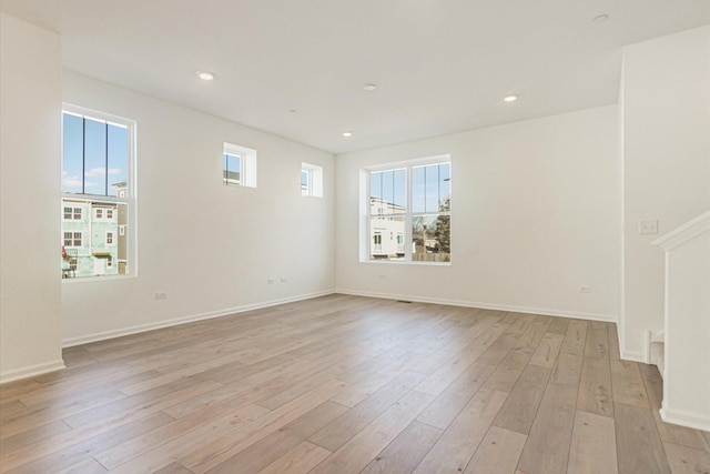 spare room featuring baseboards, recessed lighting, and light wood-style floors