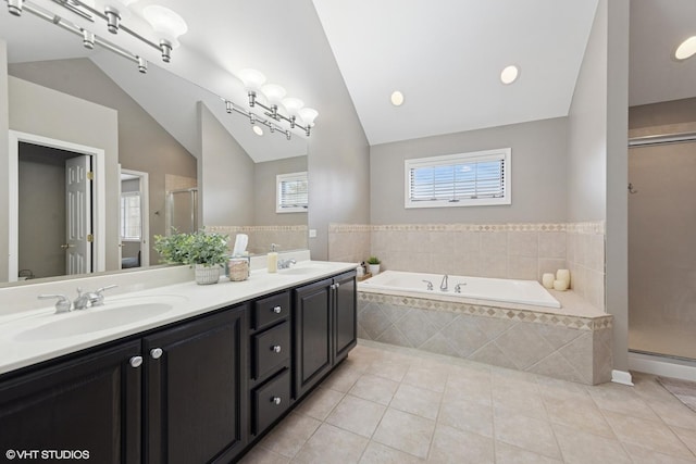 bathroom featuring a bath, a shower stall, lofted ceiling, and a sink