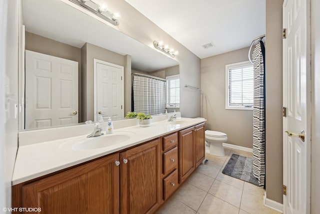full bath with a sink, double vanity, toilet, baseboards, and tile patterned flooring