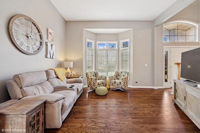 living area with dark wood-type flooring and baseboards