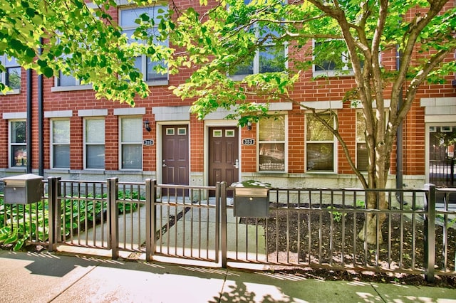 353 E Eastgate Pl, Chicago, IL 60616 - view of property featuring brick siding, a fenced front yard, and a gate