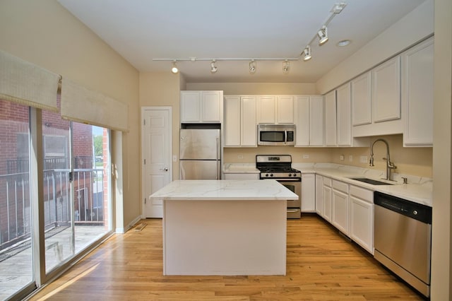353 E Eastgate Pl, Chicago, IL 60616 - kitchen with stainless steel appliances, a kitchen island, white cabinetry, and light wood finished floors