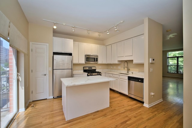 353 E Eastgate Pl, Chicago, IL 60616 - kitchen with stainless steel appliances, white cabinets, a kitchen island, and light wood-style floors