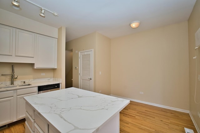 353 E Eastgate Pl, Chicago, IL 60616 - kitchen featuring stainless steel dishwasher, a center island, light wood finished floors, white cabinets, and light stone countertops