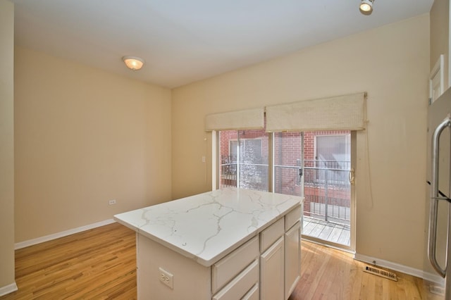 353 E Eastgate Pl, Chicago, IL 60616 - kitchen featuring light wood-style floors, a center island, and light stone countertops