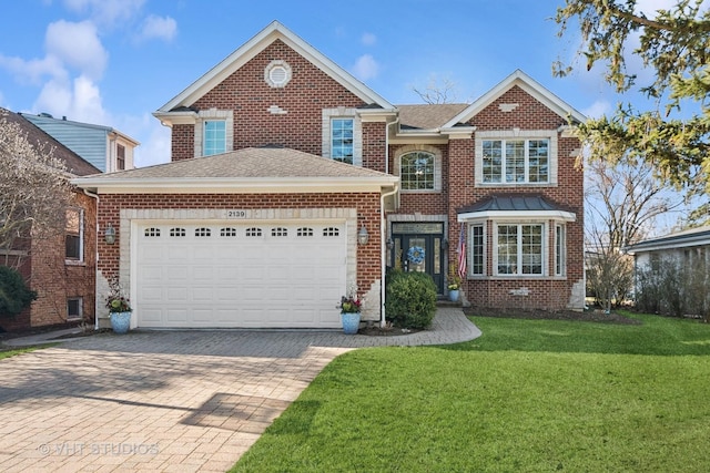 traditional-style home with roof with shingles, driveway, an attached garage, a front yard, and brick siding