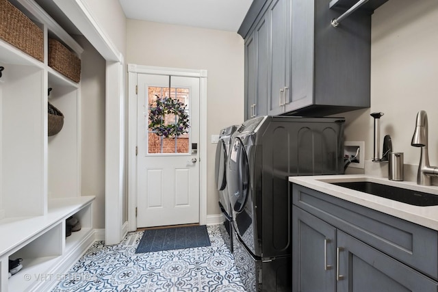 laundry area with light tile patterned floors, a sink, baseboards, cabinet space, and washer and clothes dryer