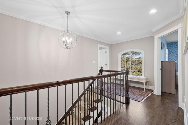hall featuring baseboards, an inviting chandelier, ornamental molding, an upstairs landing, and wood finished floors