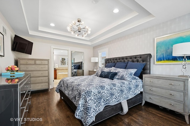 bedroom with ensuite bathroom, a raised ceiling, a notable chandelier, dark wood-style flooring, and recessed lighting
