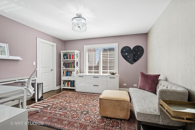 sitting room with dark wood-type flooring, baseboards, and a notable chandelier
