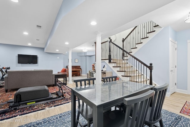 dining space featuring baseboards, recessed lighting, light wood-style floors, and stairs