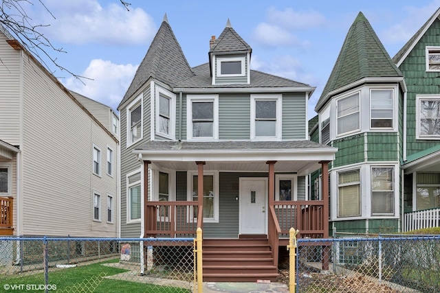 2622 N Central Park Ave, Chicago, IL 60647 - victorian-style house featuring roof with shingles, covered porch, and a fenced backyard