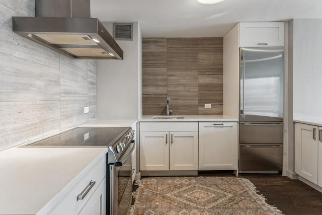 1636 N Wells St Unit 609, Chicago, IL 60614 - kitchen with wall chimney exhaust hood, stainless steel appliances, tasteful backsplash, dark wood finished floors, and white cabinets