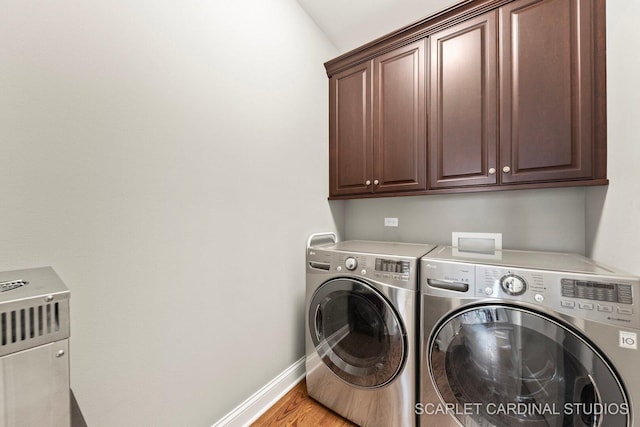 2793 Nicole Cir, Aurora, IL 60502 - clothes washing area with baseboards, washing machine and dryer, light wood finished floors, and cabinet space