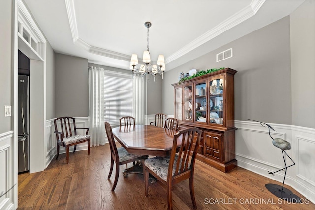 2793 Nicole Cir, Aurora, IL 60502 - dining space with visible vents, wood finished floors, a wainscoted wall, an inviting chandelier, and ornamental molding
