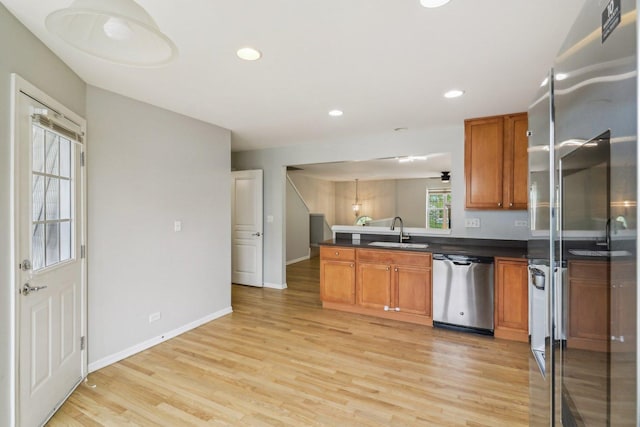 2303 Neubauer Cir, Lindenhurst, IL 60046 - kitchen featuring stainless steel appliances, a sink, brown cabinetry, dark countertops, and light wood-style flooring