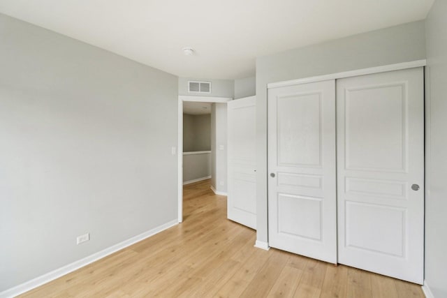 2303 Neubauer Cir, Lindenhurst, IL 60046 - unfurnished bedroom with light wood-style floors, baseboards, and a closet