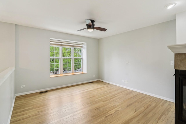 2303 Neubauer Cir, Lindenhurst, IL 60046 - unfurnished living room with light wood finished floors, a ceiling fan, a glass covered fireplace, and baseboards