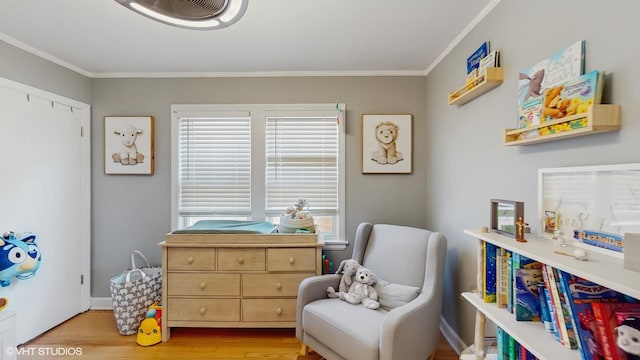 sitting room featuring crown molding, wood finished floors, and plenty of natural light