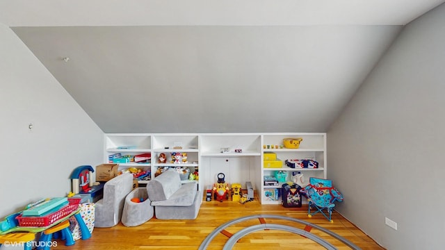 game room with vaulted ceiling and wood finished floors
