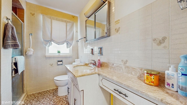 bathroom featuring toilet, tile walls, a shower stall, vanity, and backsplash