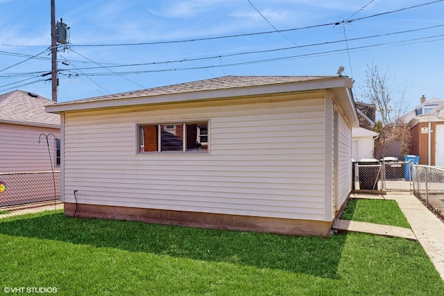 view of property exterior featuring a yard, fence, and a shingled roof