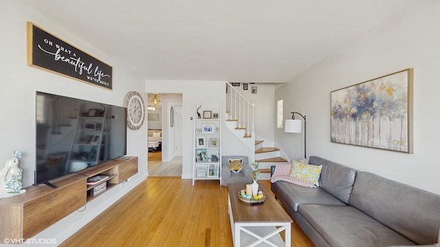 living area featuring stairway and wood finished floors