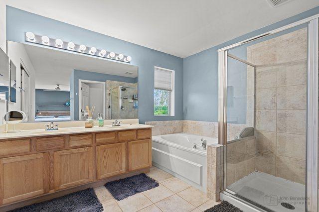 522 Superior St, Vernon Hills, IL 60061 - bathroom featuring a garden tub, a stall shower, a sink, tile patterned floors, and double vanity