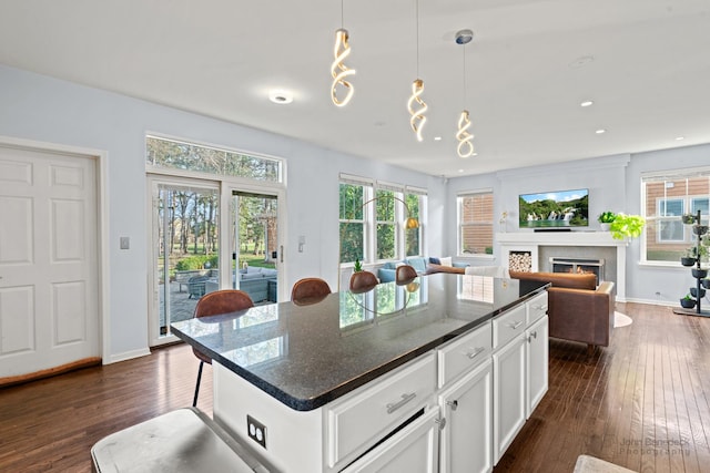 522 Superior St, Vernon Hills, IL 60061 - kitchen featuring dark wood-style flooring, a wealth of natural light, white cabinetry, and a warm lit fireplace