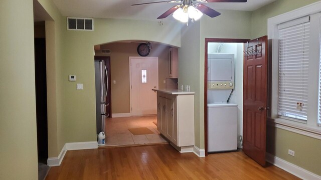 6147 N Mozart St Unit 3, Chicago, IL 60659 - laundry area featuring estacked washer and dryer, arched walkways, ceiling fan, light wood-style flooring, and baseboards