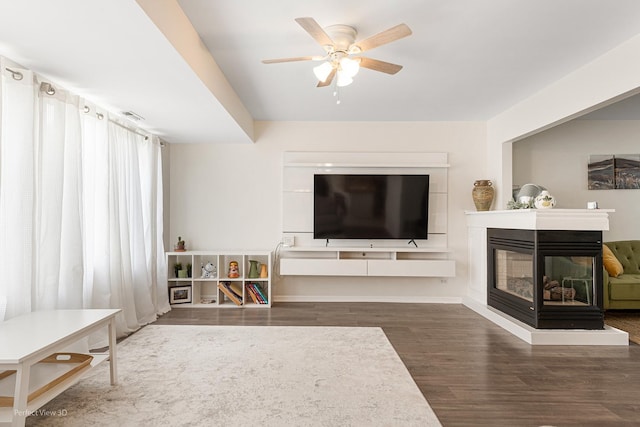 1704 Walnut Park Ln, Aurora, IL 60504 - living room featuring wood finished floors, ceiling fan, a multi sided fireplace, and baseboards