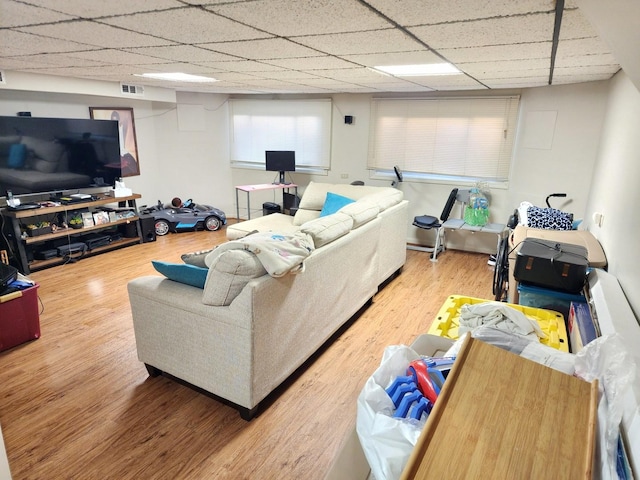 living room with a paneled ceiling, visible vents, and wood finished floors