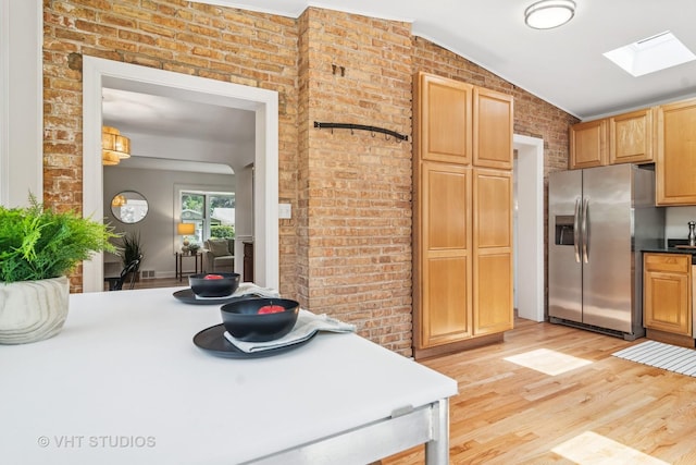 212 N Russel St, Mount Prospect, IL 60056 - kitchen featuring stainless steel fridge, light wood finished floors, brick wall, a skylight, and vaulted ceiling