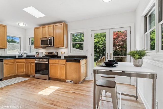 212 N Russel St, Mount Prospect, IL 60056 - kitchen with stainless steel appliances, light wood-type flooring, a skylight, and dark countertops
