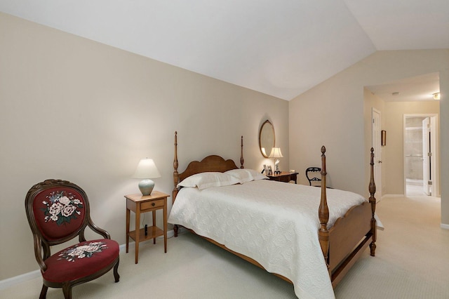 bedroom with light colored carpet, vaulted ceiling, and baseboards