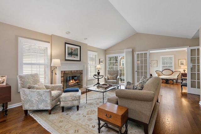 living room with lofted ceiling, a healthy amount of sunlight, a fireplace, and wood finished floors