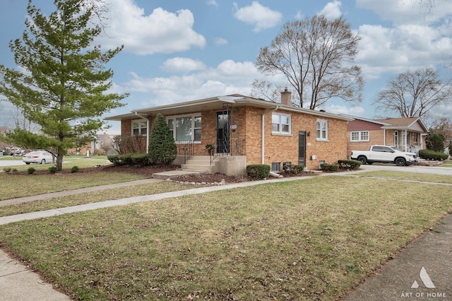 view of front of house with a chimney, brick siding, and a front lawn