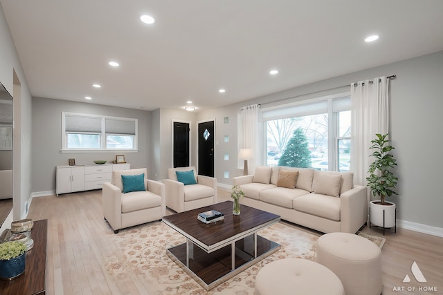 living area featuring baseboards, recessed lighting, and light wood-type flooring