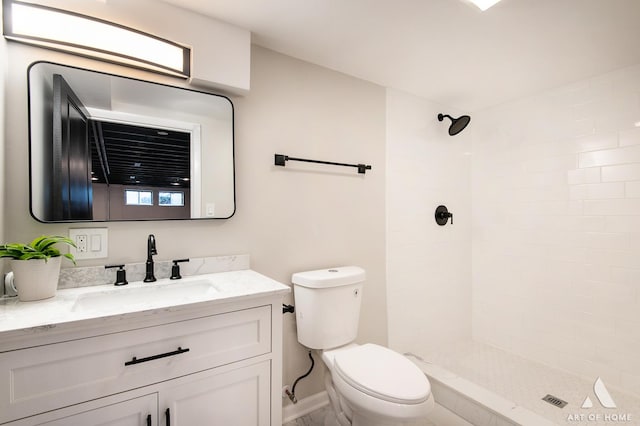full bath with toilet, vanity, and a tile shower